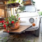 brown luggage on top of white vehicle